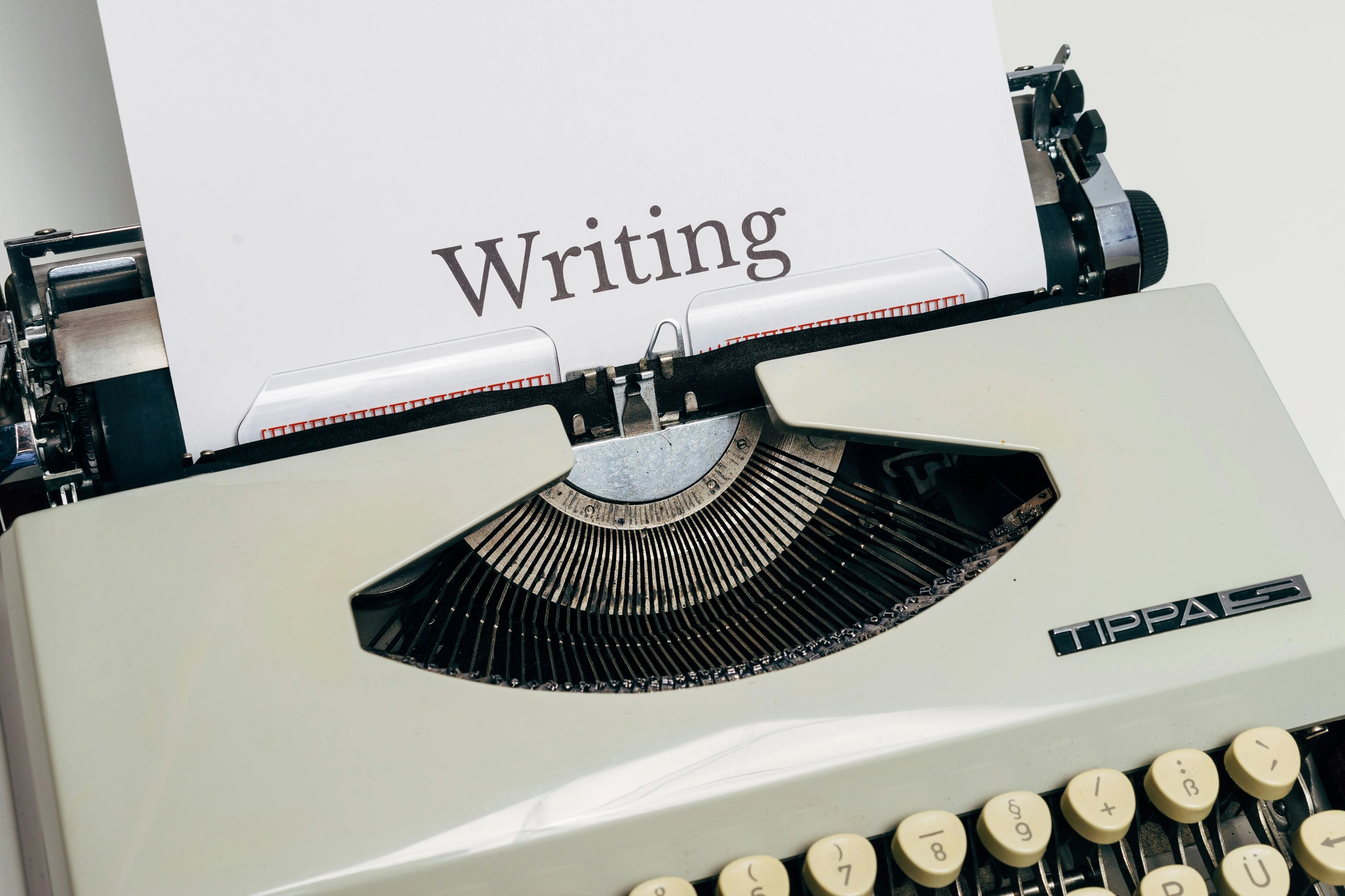 Alte Schreibmaschine mit dem Wort „Writing" – Produktbild für „One Sentence a Day" Schreibübung von Autorin Pia Klein Creative Studio
