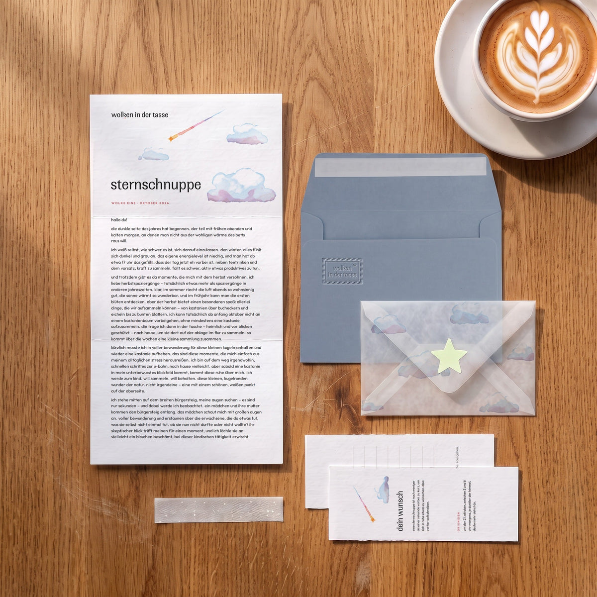 wolken in der tasse, Brief Oktober „sternschnuppe“ auf einem Eichentisch mit graublauem Umschlag, Prägung und Transparentumschlag